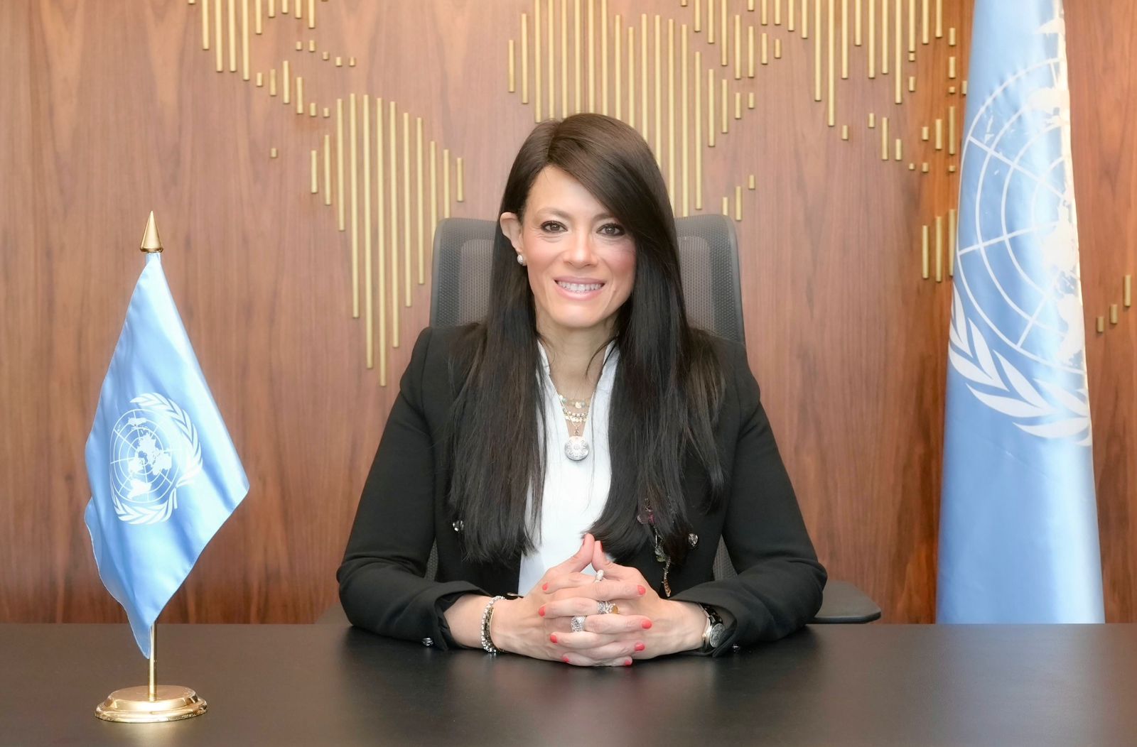 ES sitting at desk with UN flag