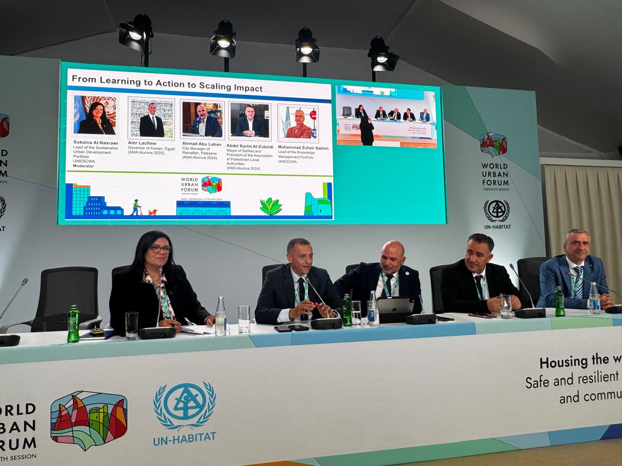 Panelists behind a table in front of a screen