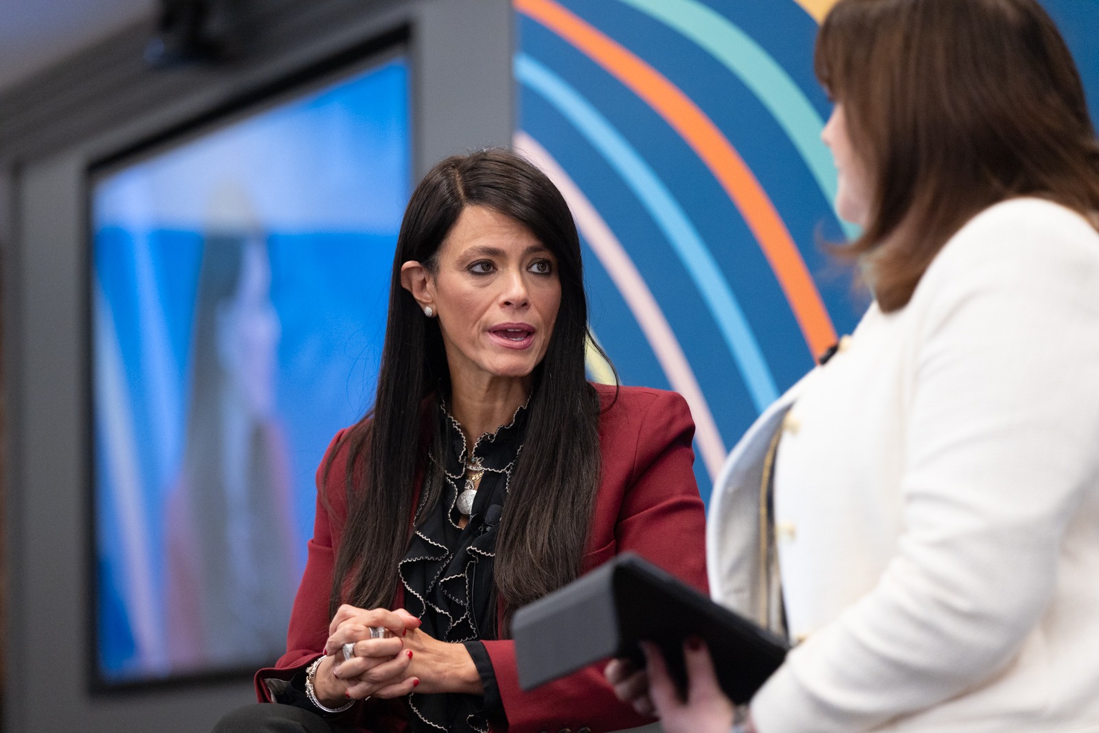 Woman in panel speaking to the moderator next to her