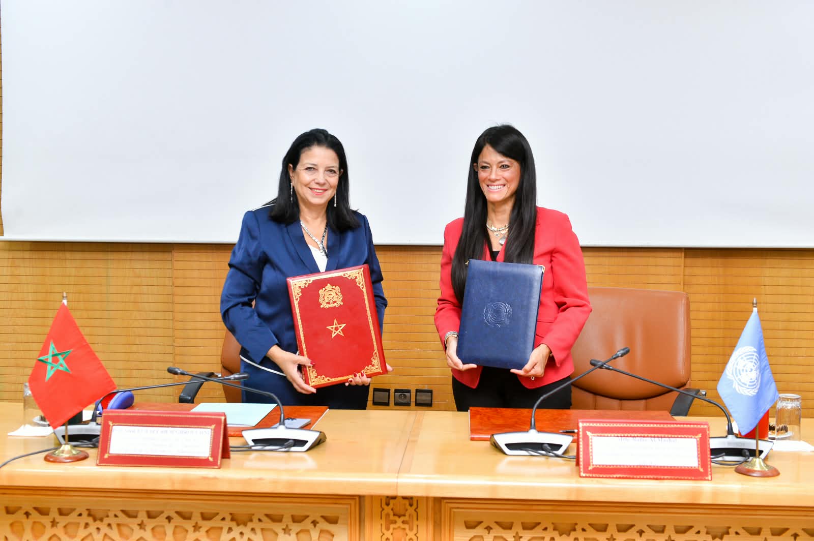 Two women senior officers holding a folder they just signed