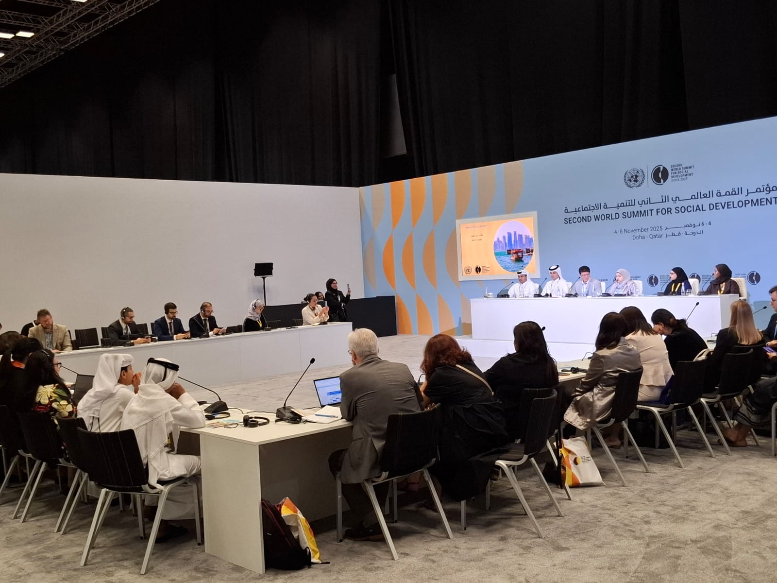 People behind a large table and a panel