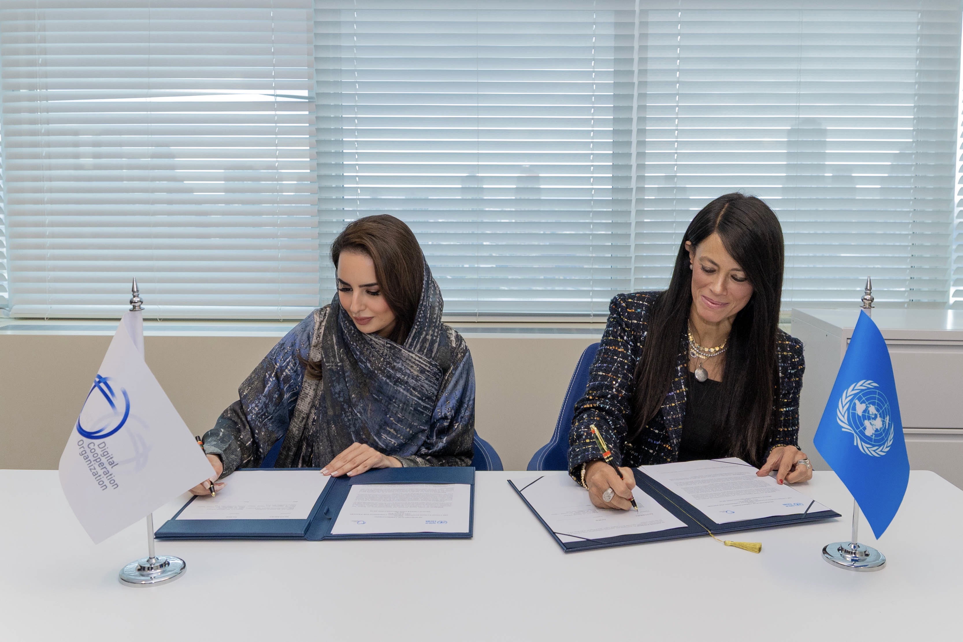 Two women senior officers signing documents at a table