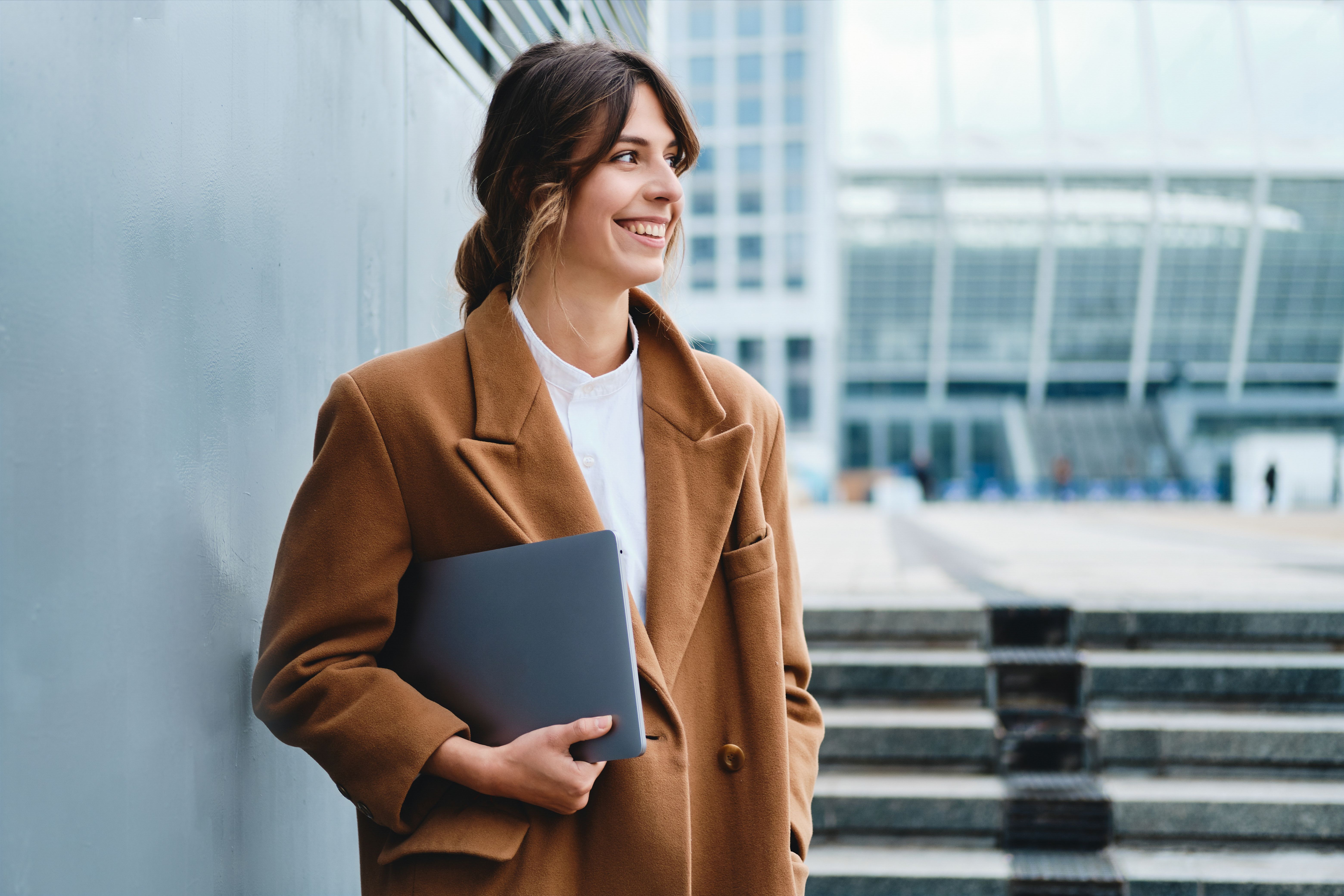 Woman holding a laptop on the outlook
