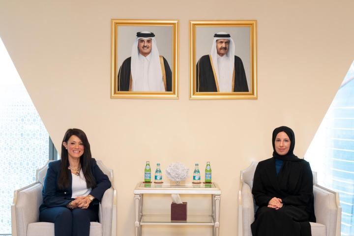 Two female officials seated on white couches