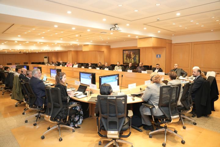 Wide photo of the room showing all participants around a large table