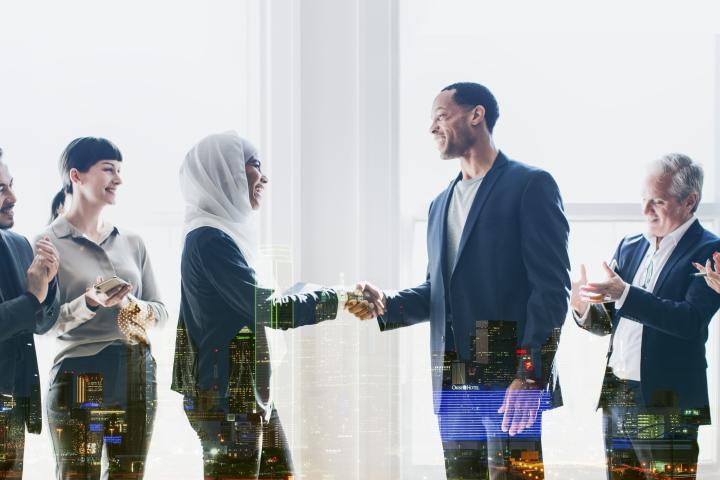 A man and a woman each surrounded by other people greeting each other