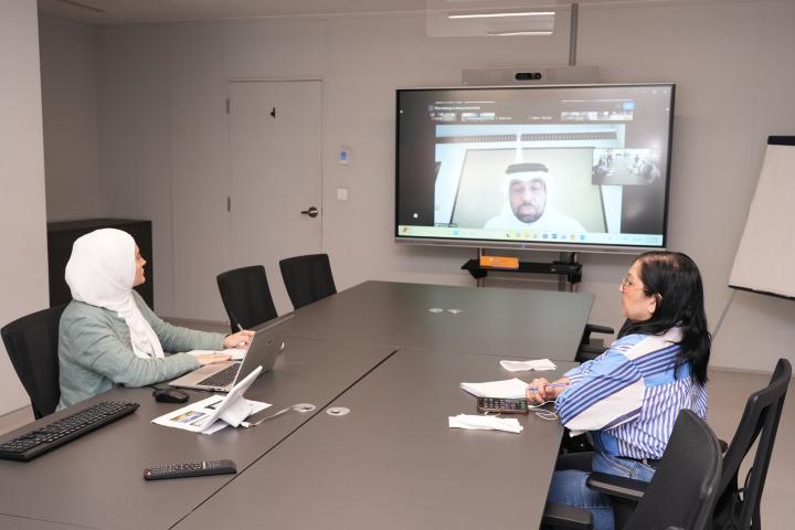 Two women seated around a table in a videoconference